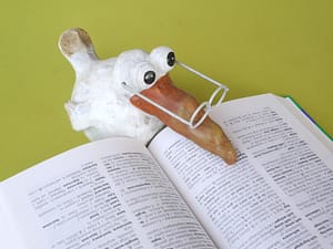 a figurine reading a book